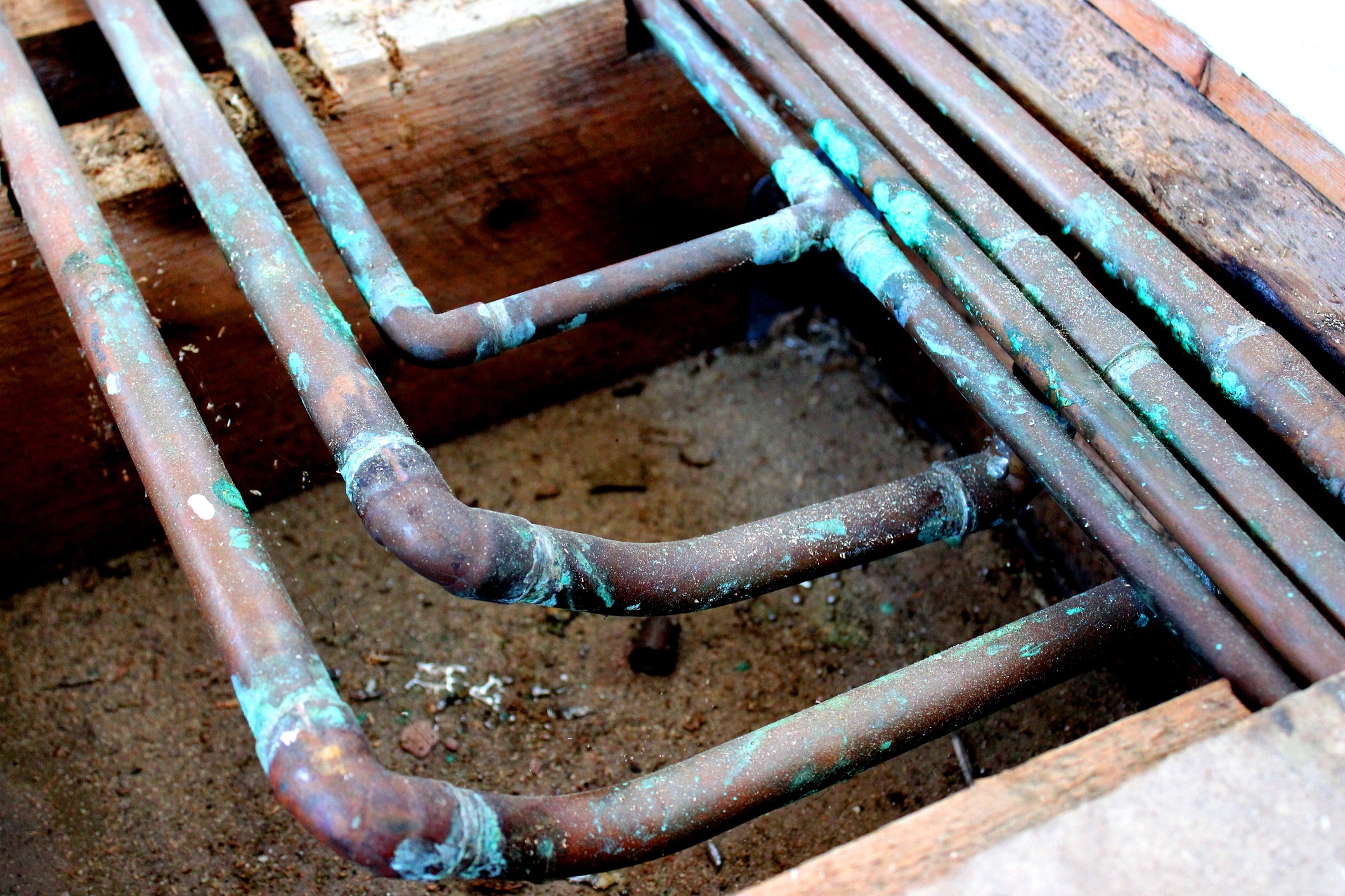 Close-up image of old copper under floor central heating pipes